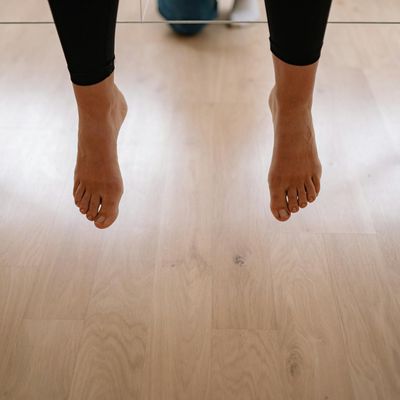 Feet in running shoes on a wooden floor